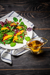 Homemade salad of fresh lettuce, mango, pomegranate and sesame on plate. Healthy food, diet, detox, clean eating and vegetarian concept with copy space