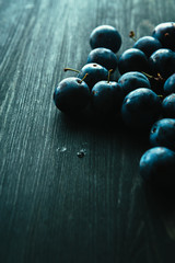 many fresh plums on black background close up