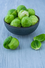 Frischer Rosenkohl in einer Schale auf einem hellen Holzuntergrund