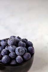 Frozen blueberries in a black ramekin