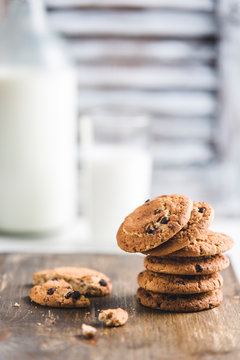 oatmeal cookies with chocolate and milk on a light background
