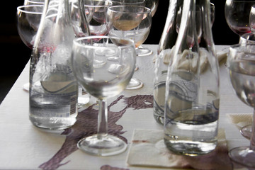 Wine glasses and bottles on the table after the exhibition opening and presentation.