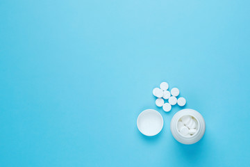 The pill bottle medicine, photo isolated on blue background. Flat lay. White pills. Copy space.