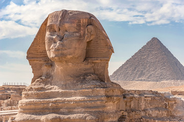 Sphinx monument against the background of large pyramids on a sunny day