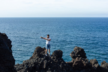 Fototapeta na wymiar Tourist taking selfie on the background of the sea.