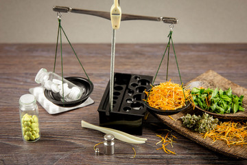 Healthy balance between herbal medicine and pharmaceutical drugs concept. Different medicament on...