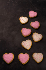 Obraz premium heart shaped sugar cookies with white, pink icing, dark background