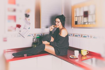 Mujer feliz en la cocina desayunando
