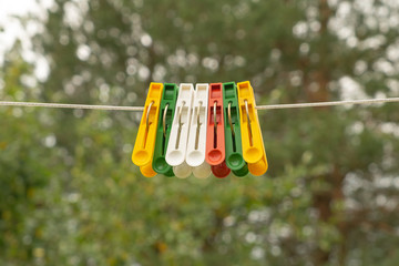 Clothespins on green background. Clothespins hanging on a rope