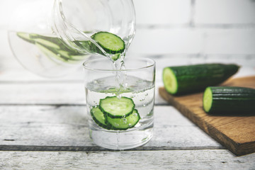 detox drink - fresh cucumber water pouring into a glass