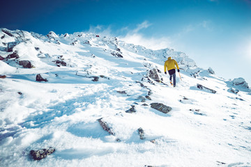 A climber ascending a mountain in winter