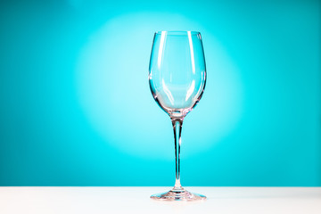 Clear drinking glass isolated on cyan blue background.