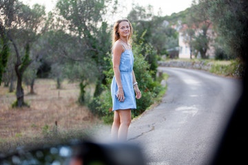 tourist girl walking on the road, the view from the car