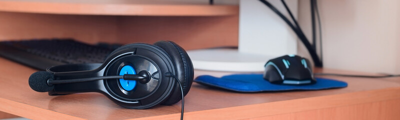 Naklejka na ściany i meble Big black headphones lie on the wooden desktop of the sound designer