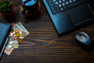 laptop and money on the wooden table