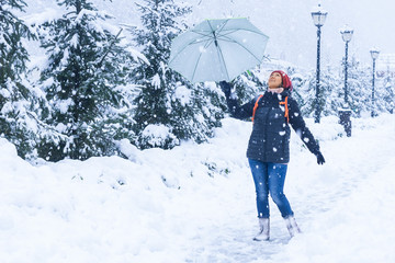 middle-aged woman of Asian appearance walking in a park in winter in snowfall