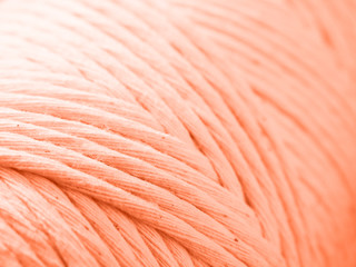 Cotton cord for macrame. Skein closeup. Сoral background