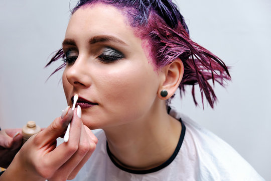 Beautiful girl with violet hair on white background master in make-up.