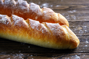 Fresh French loaf with a ruddy crust on a wooden table