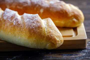 Fresh French loaf with a ruddy crust on a wooden table
