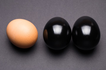 Black and brown egg on a gray background close-up