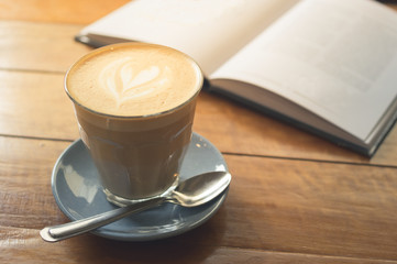 Hot coffee in glass cup with book.