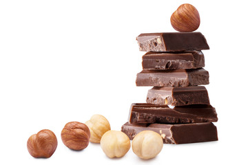 Chocolate pieces and hazelnuts, isolated on white background