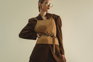 stylish model posing in trendy retro clothing for fashion shoot isolated on beige