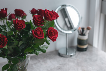 Dressing Table Marble Vanity Table Mirror Make up Brushes Bouquet Red roses Flower Girlish Beauty Fashion Selective Focus 