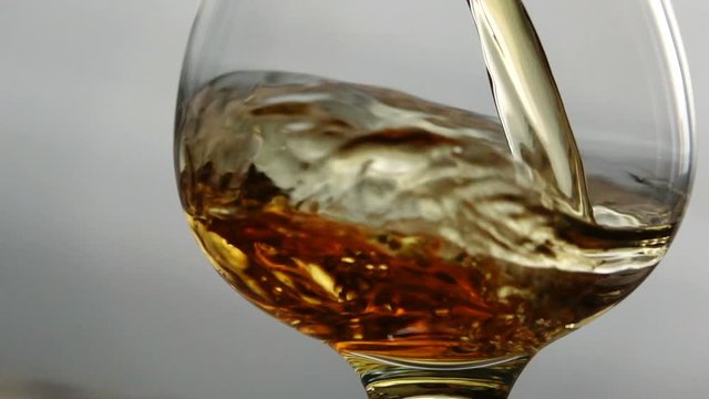 Cognac is poured into a glass in Slow Motion shot. Seamless cinemagraph video.