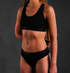 Fototapeta na wymiar sexy Fitness body in sport underwear on black background 