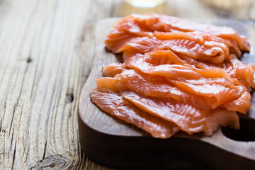 Smoked salmon on wooden board, sliced
