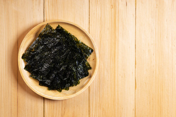 Crispy dried seaweed on wooden dish