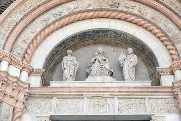 Fototapeta na wymiar Madonna and Child with Saints, Lunette of San Petronio Basilica by Jacopo della Quercia in Bologna, Italy