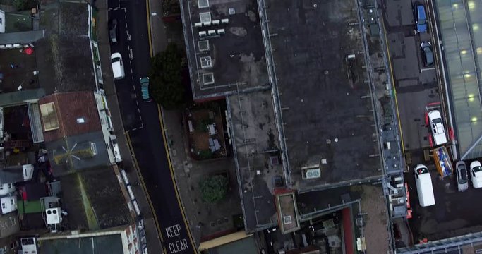 Aerial top down tracking shot of unrecognizable black car driving through urban town setting. Shot in Gravesend, Kent, UK