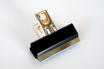 Black color bulldog clip isolated on white background. 