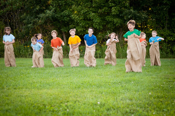 Obraz premium Happy Kids Having Potato Sack Race Outside