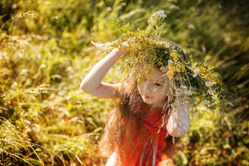 Portrait of a little girl in wreath of flowers