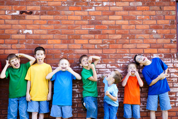 Group of Boys Making Faces by Brick Wall Outside