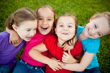 Fototapeta premium Group of Happy Girls Sitting in Grass Outside