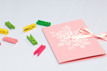 Making greeting card from paper, cardboard and tape. Near the surface are decorative accessories.