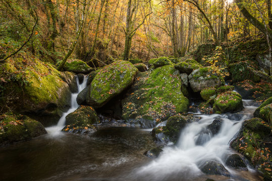 Waterfalls between granite rocks covered with moss