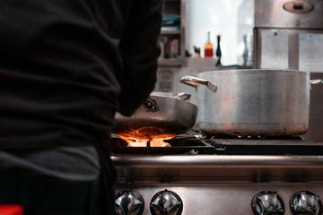 Young migrants working in Europe. Apprentice chef, job and occupation issues. Industrial restaurant kitchen details