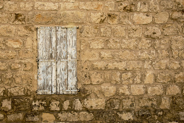 Grunge Weathered closed Window in old abandoned stone house wall