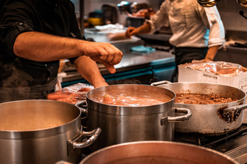 Vegan Soup. Young migrants working in Europe. Apprentice chef, job and occupation issues. Industrial restaurant kitchen details