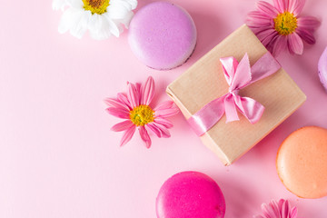 Photo of cake macarons, gift box, tea, coffee, cappuccino and flowers. Sweet romantic food macaroon concept. Morning breakfast and presents. Valentine's day concept.
