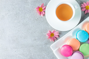 Photo of cake macarons, gift box, tea, coffee, cappuccino and flowers. Sweet romantic food macaroon concept. Morning breakfast and presents. Valentine's day concept.
