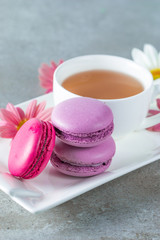 Photo of cake macarons, gift box, tea, coffee, cappuccino and flowers. Sweet romantic food macaroon concept. Morning breakfast and presents. Valentine's day concept.