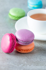 Photo of cake macarons, gift box, tea, coffee, cappuccino and flowers. Sweet romantic food macaroon concept. Morning breakfast and presents. Valentine's day concept.