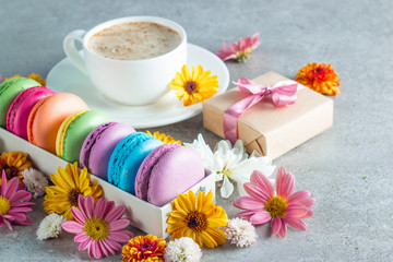 Obraz na płótnie Canvas Photo of cake macarons, gift box, tea, coffee, cappuccino and flowers. Sweet romantic food macaroon concept. Morning breakfast and presents. Valentine's day concept.